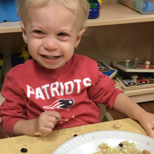 Once beset by nutrition issues, Grey Greenough enjoys a recent lunch at daycare. (Photo courtesy of Jessica Pennell.)