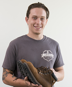 Billy Morrissey with boots his mother donated to the bridge clinic.