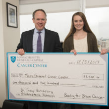 Elana Sargent presents a check for $1,500 to her father's neuro-oncologist, Dr. Tracy Batchelor, for glioblastoma research.