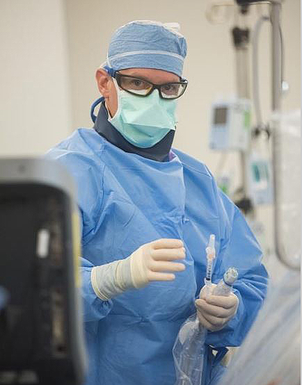 Joshua Caplin, PA, prepares to take a cardiac biopsy, part of Dennis Kaminski's follow-up care. 
