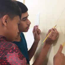 At the MGH Revere HealthCare Center Youth Zone, two campers layout the design for a full-sized wall mural.