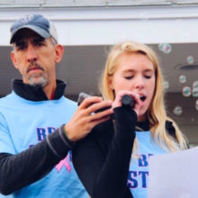 Grace Elmer and her father, Bob Elmer, at a 2018 Breast Friends Walk, while Grace addresses participants.
