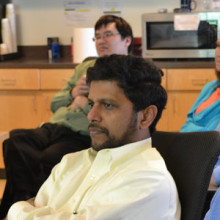 Mark J. Daly, PhD (right foreground), and Ramnik J. Xavier, MD (center), listen intently to a presentation in the Mass General Gastrointestinal Unit