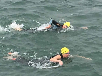 Swimmers brave chilly waters in the Swim Across America Boston Harbor Islands Swim, which raises funds for pediatric cancer research.