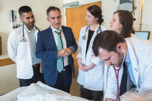 Alberto Puig, MD, PhD (second from left), director of the Core Educator Faculty Service at Mass General, confers with a group of medical students. 